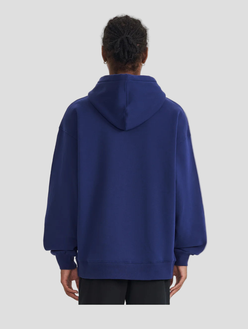 Person wearing a blue hoodie from behind on a light gray background