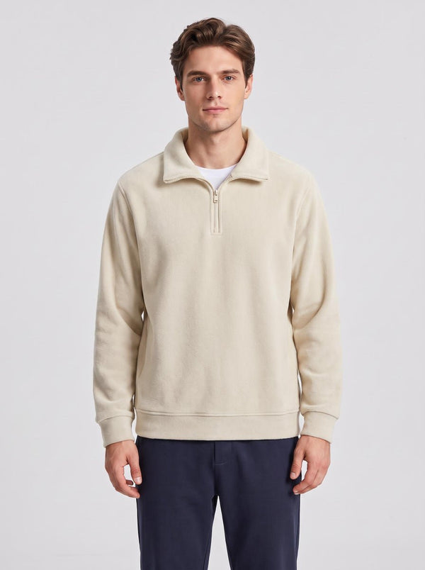 European male model wearing #khaki half-zip fleece pullover, front standing pose, hands relaxed at sides, plain grey background, men casual fleece top
