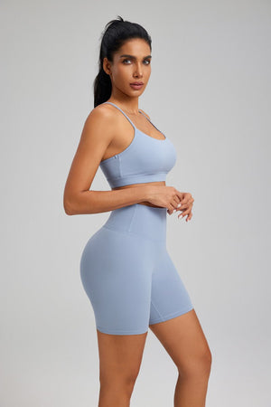 Woman wearing a light #blue athletic outfit with shorts and yoga top