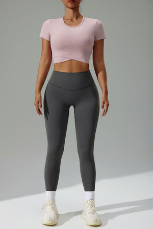 Person wearing a #pink crop top and gray leggings