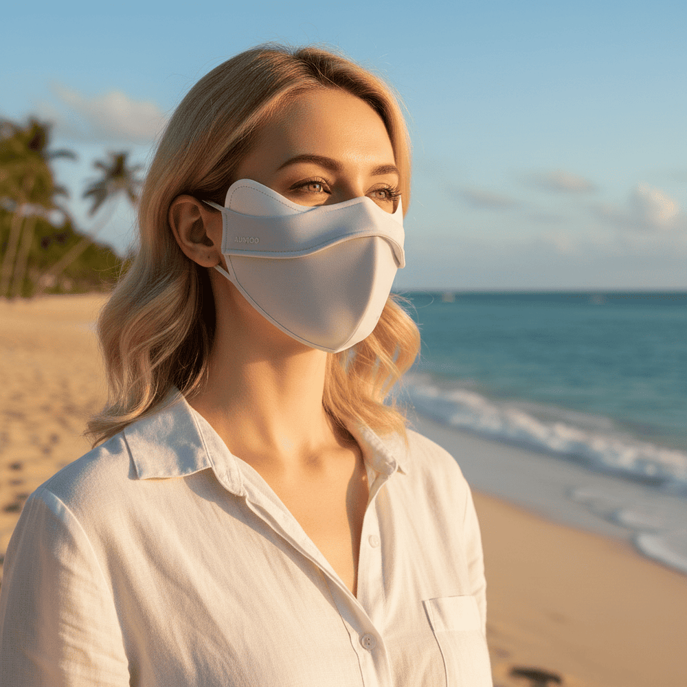 Woman wearing a white face mask on a beach with palm trees and ocean in the background