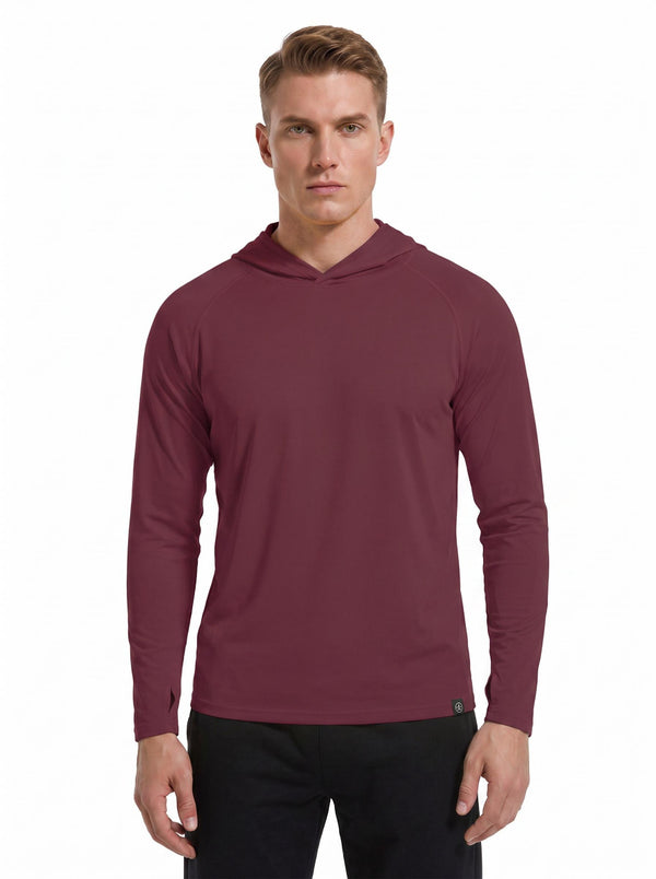 A male model wearing a #maroon hooded long-sleeve performance shirt and black athletic pants stands against a plain white background. 