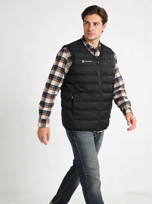 A man wearing a #black heated puffer vest over a beige and brown plaid flannel shirt, paired with blue jeans, photographed against a plain white studio background.