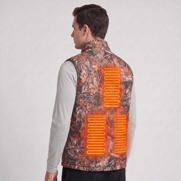 Back view of young British male model wearing woodland camo heated vest, glowing orange heating zones on upper and lower back, plain light gray studio background