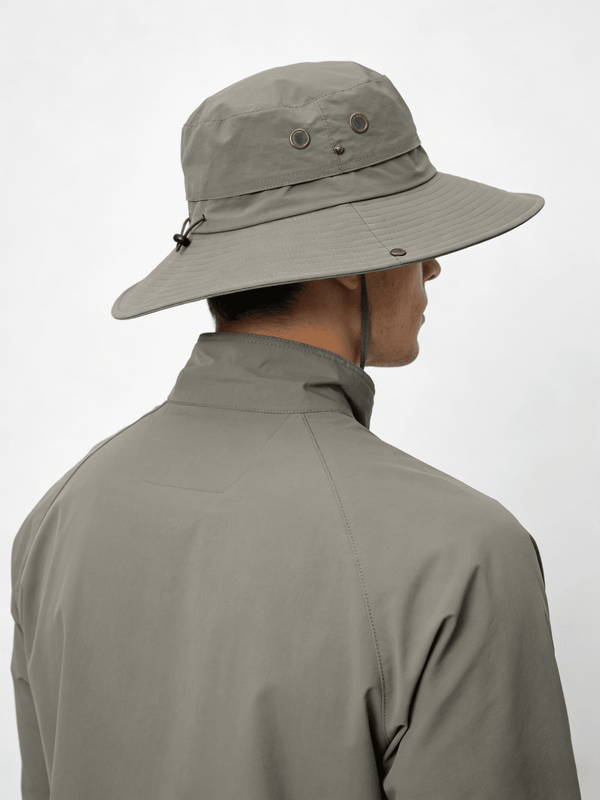 Person wearing a beige wide-brimmed hat and matching jacket on a white background