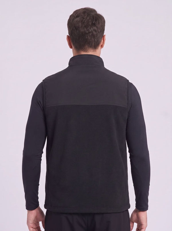 A man viewed from the back wearing a black heated fleece gilet