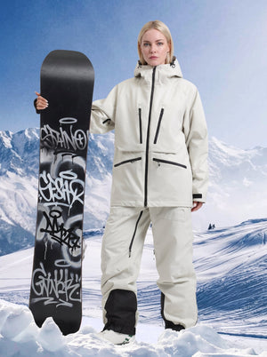 Blonde female model wearing #beige oversized women snow suit, standing on snow with graffiti snowboard, snow mountain background, professional waterproof ski suit set for snowboarding.