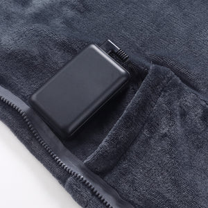 Portable power bank stored in built-in pocket of dark gray wearable heated blanket, USB power supply for heating cape