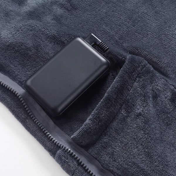 Portable power bank stored in built-in pocket of dark gray wearable heated blanket, USB power supply for heating cape