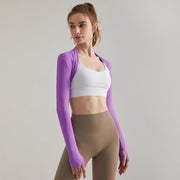 Woman wearing a purple long-sleeve Sun Protection Cooling Arm Wrap, white sports bra, and blue leggings on a light gray background