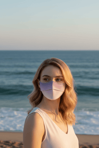 Woman wearing a purple face mask on a beach with ocean in the background