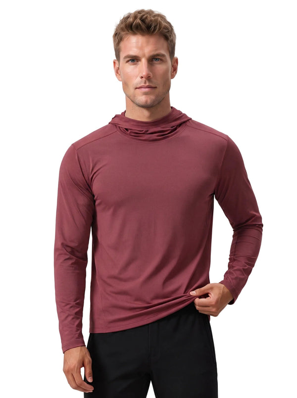Caucasian male model wearing #maroon hooded long-sleeve sun protection shirt and black trousers, gripping the hem of the top, plain light gray background.