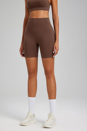 woman wearing #brown athletic top and shorts with white socks and shoes on