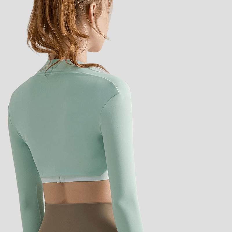 Person wearing a light green athletic outfit shoulder wrap on a plain background