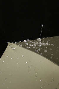 Close-up of a wet umbrella with water droplets on a black background