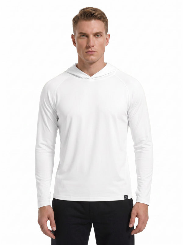 A male model wearing a #white hooded long-sleeve performance shirt and black athletic pants stands against a plain white background. 