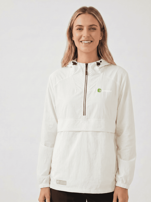 A woman wearing a #white hooded lightweight UV jacket with a half-zip front, black drawstrings, and a small green logo on the left chest, photographed against a plain light gray studio background.