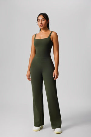 Woman wearing a #green jumpsuit on a gray background 